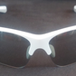 White-framed sunglasses with dark lenses on a reflective surface